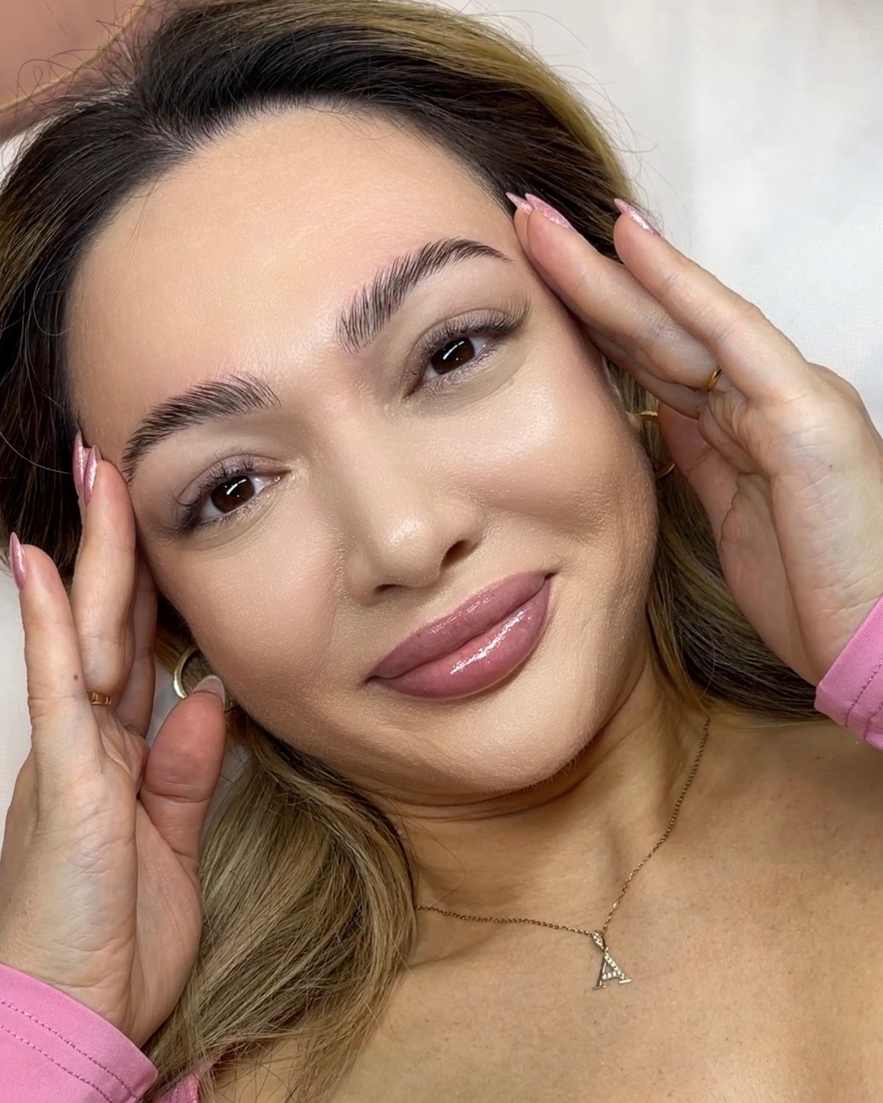 Freshly shaped brows at Bellacure: a smiling guest with her hand at her temple