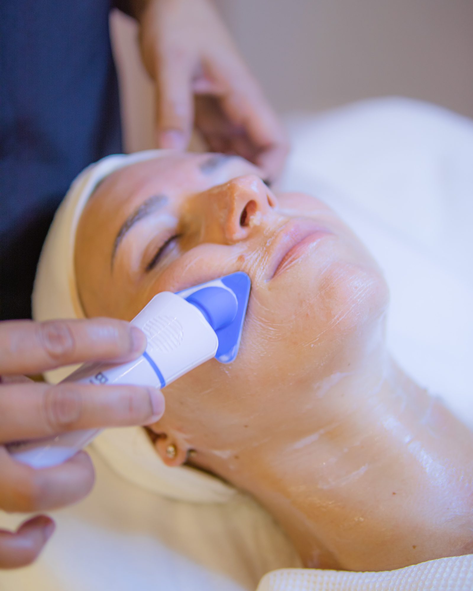 A facial in progress at Bellacure, the therapist working a skin device along the cheek